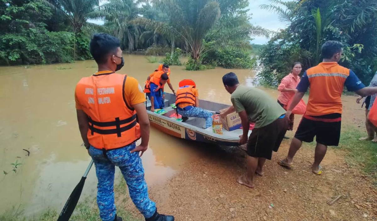 ANGGOTA Angkatan Pertahanan Awam Malaysia (APM) Daerah Muallim menggunakan bot untuk menghantar makanan kepada penduduk orang Asli di Kampung Changkat Ramu dan Buluh Seruas apabila penduduk terputus hubungan akibat jalan masuk dinaiki air. FOTO Ihsan pembaca