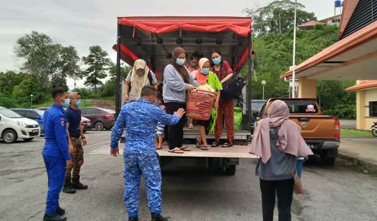 ANGGOTA APM Beaufort membantu memindahkan mangsa banjir di Pusat Pemindahan Sementara (PPS) Dewan Datuk Mohd Dun Banir. FOTO Ihsan APM Beaufort