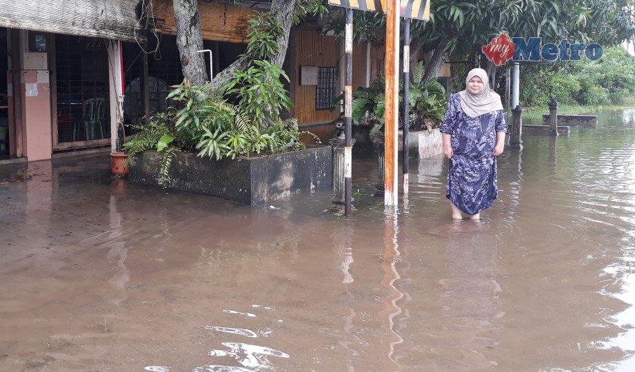  RAJA Gamar  menunjukkan keadaan banjir di depan kedai makannya di Jalan Lama Seremban-Port Dickson. FOTO Mohd Khidir Zakaria