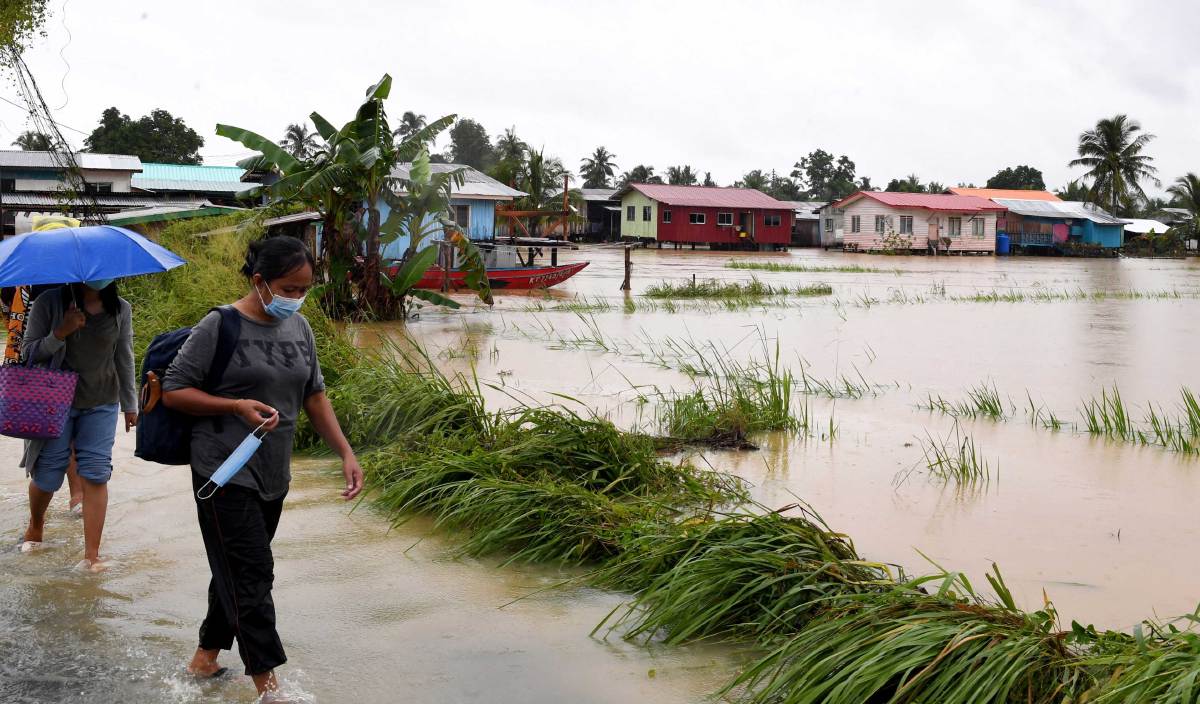 PENDUDUK Kampung Korina Sikuati meninggalkan rumah mereka untuk berpindah ke pusat penempatan banjir di SK Sikuati, Kudat apabila rumah mereka dinaiki banjir hari ini. FOTO BERNAMA