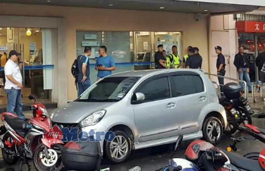 ANGGOTA polis melakukan siasatan di sebuah bank yang dirompak dua lelaki di Jalan Genting Klang, Setapak, Kuala Lumpur, hari ini. FOTO Teoh Pei Ying