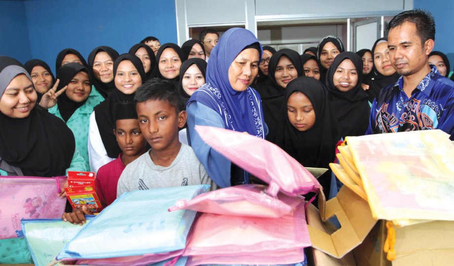 SETIAUSAHA Persatuan Pandu Puteri Pahang Datin Seri Jamaliah Zainal Abidin menyampaikan sumbangan alat tulis kepada murid etnik Rohingya pada program School Kits for Rohingya.