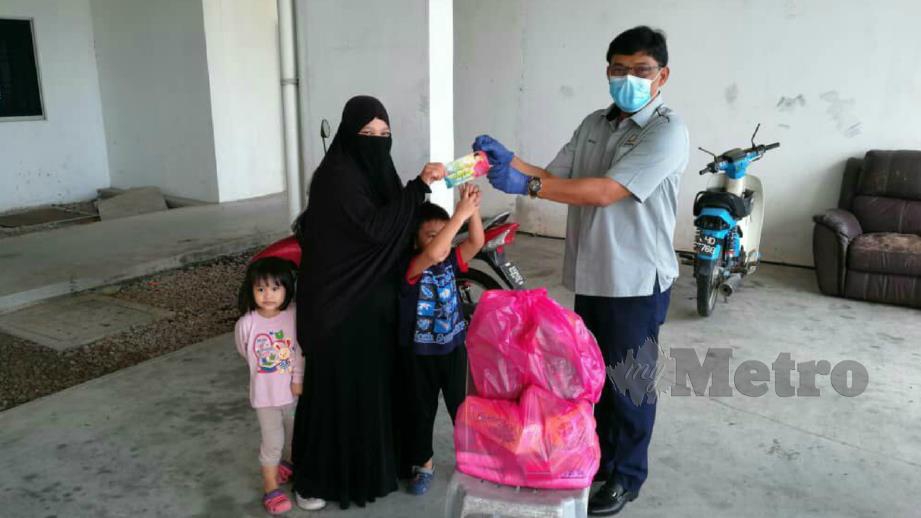 Mohd Izhar menyampaikan bantuan wang tunai dan barang keperluan asas kepada Noradilah di Kampung Bakar Batu, Johor Bahru hari ini. Foto Ihsan Pejabat Exco 