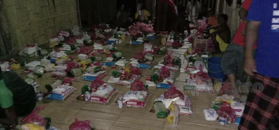  BUNGKUSAN makanan keperluan yang dibeli disusun sebelum proses agihan dibuat kepada 65 keluarga di Kampung Pelug, Gua Musang. FOTO ihsan Nur Amalina Ismail