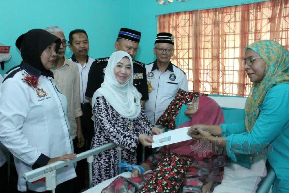 ZARINA (kanan) menerima sumbangan dari PERKEP Kontinjen Johor dikediamannya. FOTO AHMAD ISMAIL