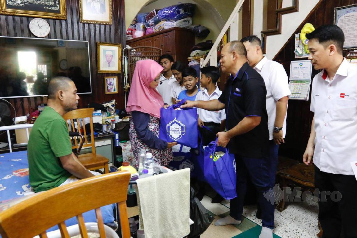 Hussain Jahit menyerahkan sumbangan kepada ibu Faisal Inwar dirumahnya di Georgetown, Pulau Pinang. FOTO SADIQ SANI