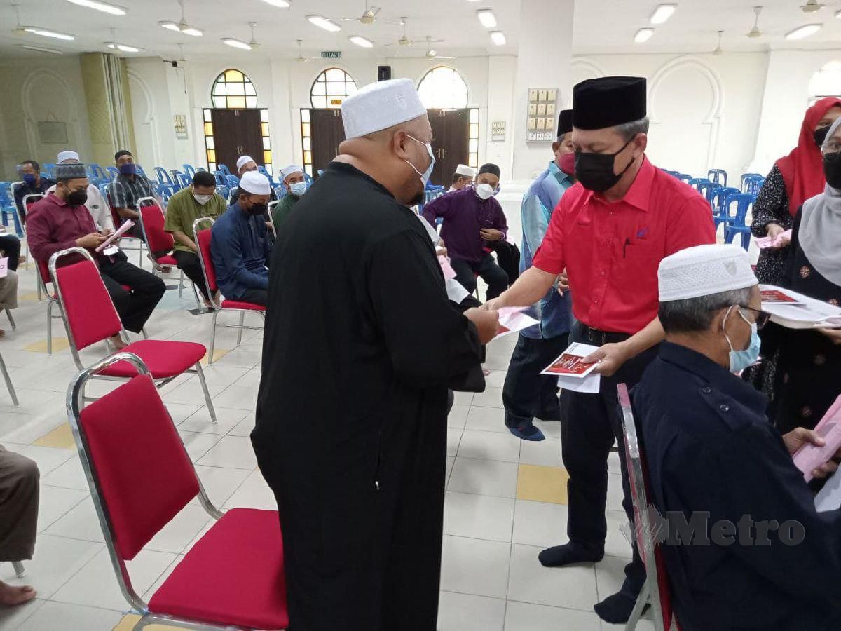 Razali (kanan) menyampaikan bantuan sekali bayaran kepada imam Masjid Sultanah Nur Zahirah, hari ini. FOTO BAHAROM BAKAR