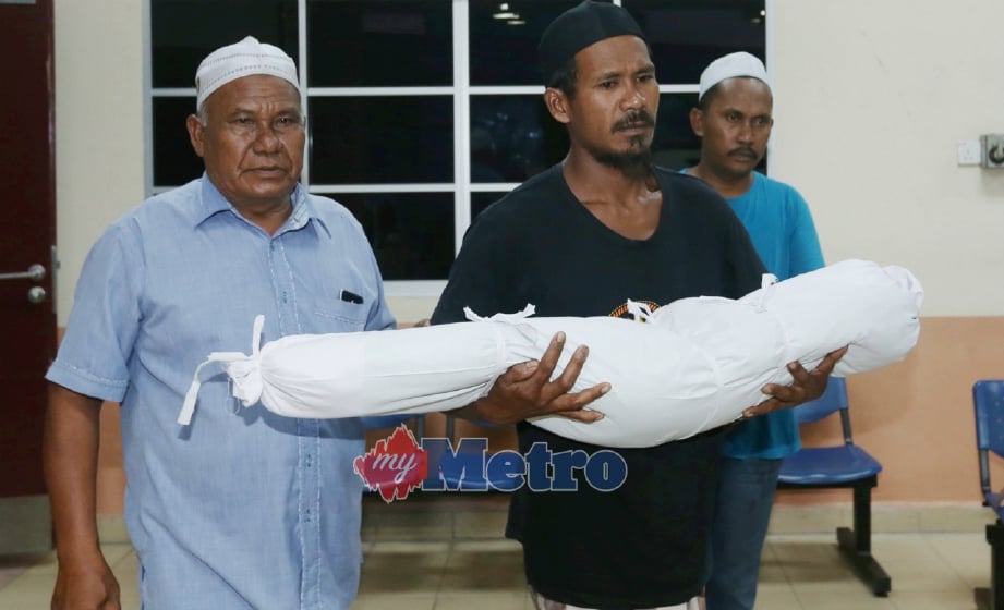 MOHD Fadzil mendukung jenazah Muhammad Firash Zaffril keluar dari Jabatan Forensik HRPB, Ipoh untuk dikebumikan di Tanah Perkuburan Islam Ulu Dedap, Seberang Perak. FOTO Muhaizan Yahya