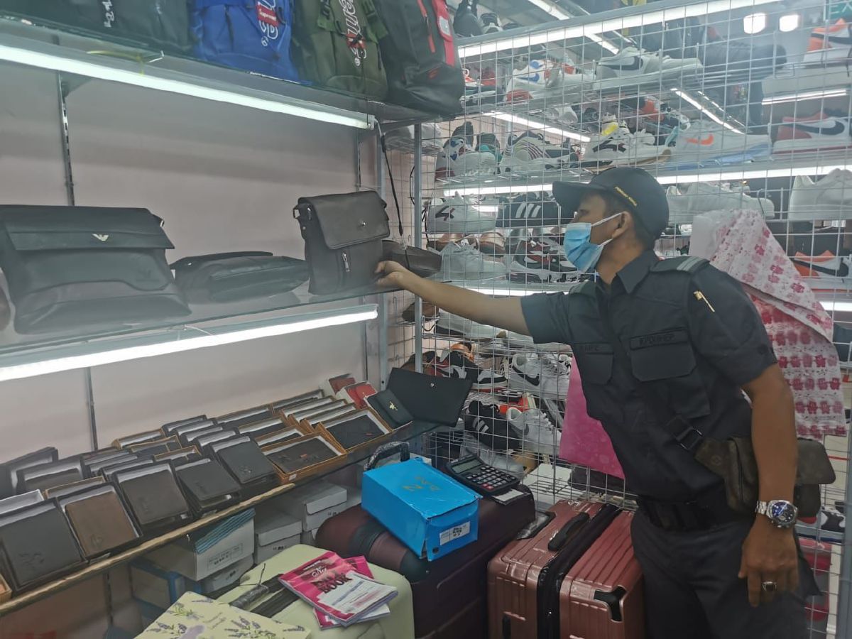 ANGGOTA penguatkuasa KPDNHEP Kuala Lumpur membuat pemeriksaan terhadap barang tiruan berjenama yang dirampas dalam serbuan di empat premis di Jalan Bukit Bintang dan Jalan Kenanga, Kuala Lumpur, Khamis lalu.