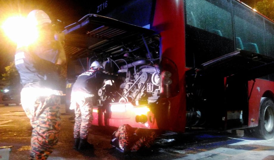 ANGGOTA bomba memeriksa keadaan enjin bas yang terbakar. 
