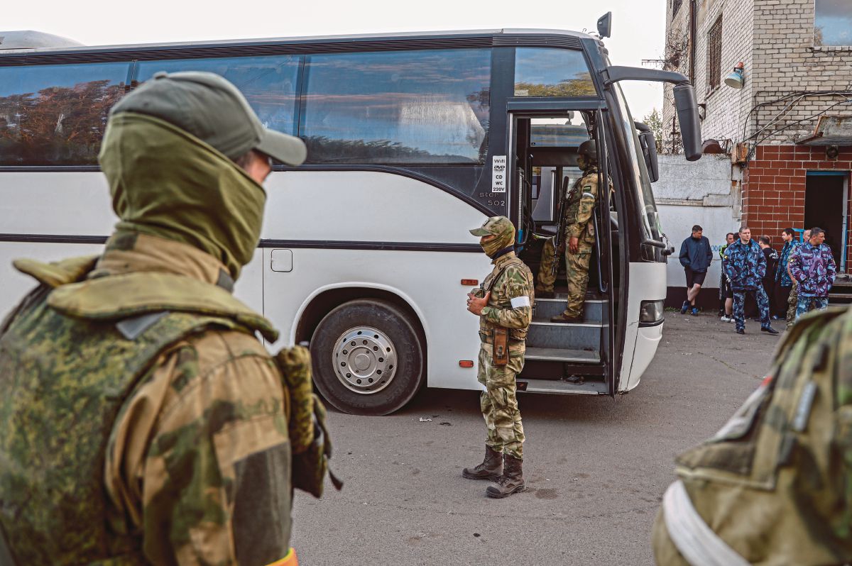 TENTERA Rusia mengawal bas yang membawa pejuang Ukraine yang menyerah diri dari kepada tentera Rusia di kilang keluli Azovstal di Mariupol. FOTO EPA 