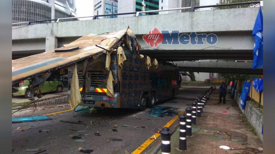 BUMBUNG bas eskpres dua tingkat yang tercabut ketika melaui laluan bawah jejambat di Jalan Tun H S Lee, Kuala Lumpur, hari ini. FOTO Ihsan PDRM