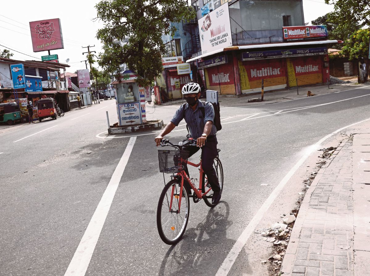 THUSITHA menunggang basikal untuk ke tempat kerjanya di Colombo. -FOTO  Reuters