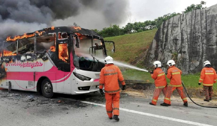 ANGGOTA bomba berusaha keras memadam api pada bas tanpa penumpang yang terbakar di Kulai. FOTO ihsan Bomba