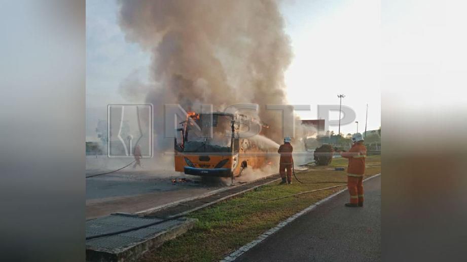 ANGGOTA bomba memadamkan kebakaran membabitkan bas sekolah. FOTO FB Malaysian Response Team