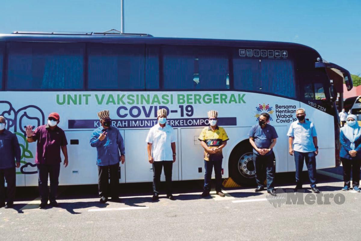 ABDUL Rahman (lima dari kanan)   berada di hadapan satu daripada 17  Bas Bergerak MARA LINER Sdn Bhd yang digunakan untuk    Program Vaksinasi Masyarakat Orang Asli.