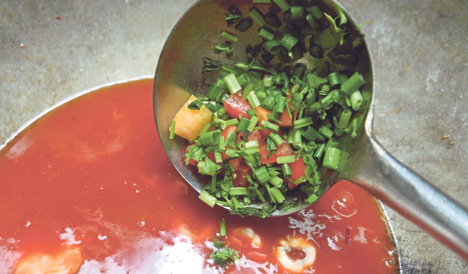 6. MASUKKAN tomato, daun sup dan daun bawang, kacau hingga kuah pekat.