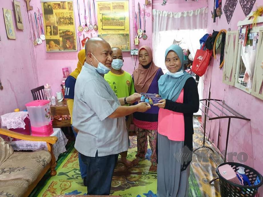 NOR AZMI (kiri) menyampaikan sumbangan kepada Siti Khalijah di rumahnya di Kampung Pamah Kasih. FOTO SHAHRINNAHAR LATIB
