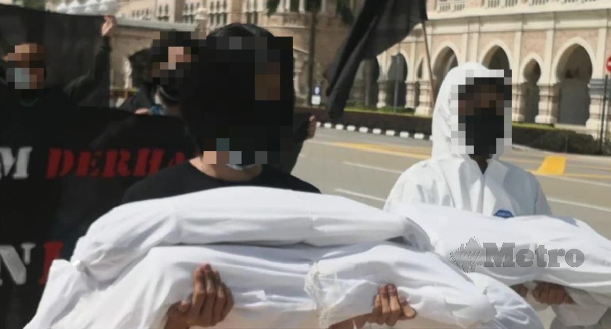 ANTARA individu yang membawa bendera hitam dan lima patung menyerupai jenazah dikapan berkumpul di Padang Dataran Merdeka. FOTO tular media sosial 