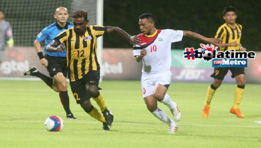 Gary Steven Robbat (kiri) berebut bola dengan pemain Timor Leste, Fernandes Ezequeil ketika perlawanan Kumpulan B Sukan SEA ke-28 Singapura 2015 di Stadium Bishan, Singapura. FOTO Hairul Anuar Abd Rahim