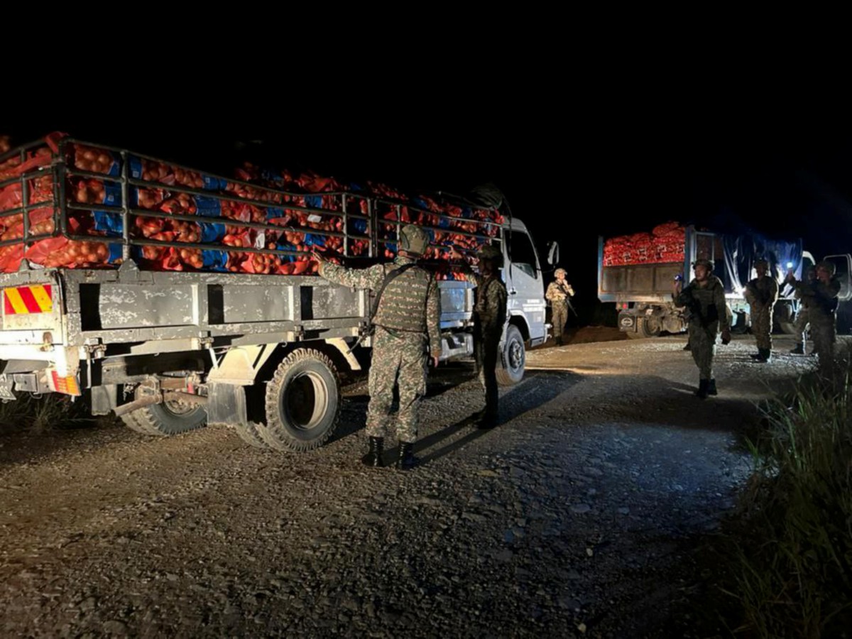 ANGGOTA tentera menahan dua lori membawa muatan bawang di Ladang Kelapa Sawit Empaling, Kampung Stass, Bau, malam tadi. FOTO Ihsan MK PMTTD.