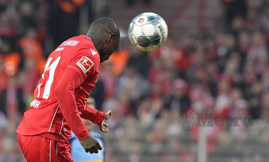 PENYERANG Union Berlin dari Nigeria, Anthony Ujah menanduk masuk gol pertama menentang Moenchengladbach. — FOTO AFP