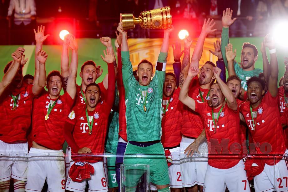 KAPTEN Bayern, Neuer (tengah) menjulang trofi Piala Jerman selepas menewaskan RB Leipzig di Berlin, awal pagi tadi. — FOTO EPA