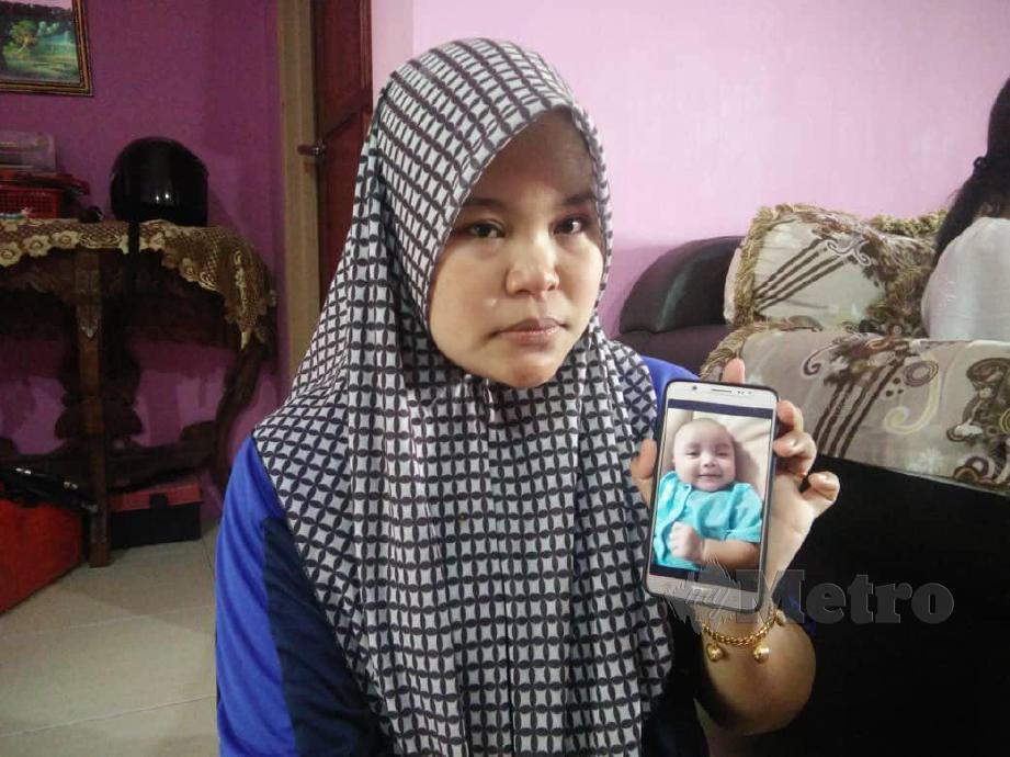 SITI Halijah menunjukkan gambar anaknya yang meninggal dunia semalam. FOTO Nor Farhani Che Ad.