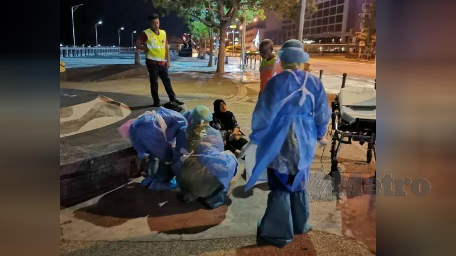 KAKITANGAN hospital membantu mengangkat wanita yang bersalin di kawasan Dataran Todak, untuk dihantar ke HWKKS Kota Kinabalu, malam tadi. FOTO Juwan Riduan. 