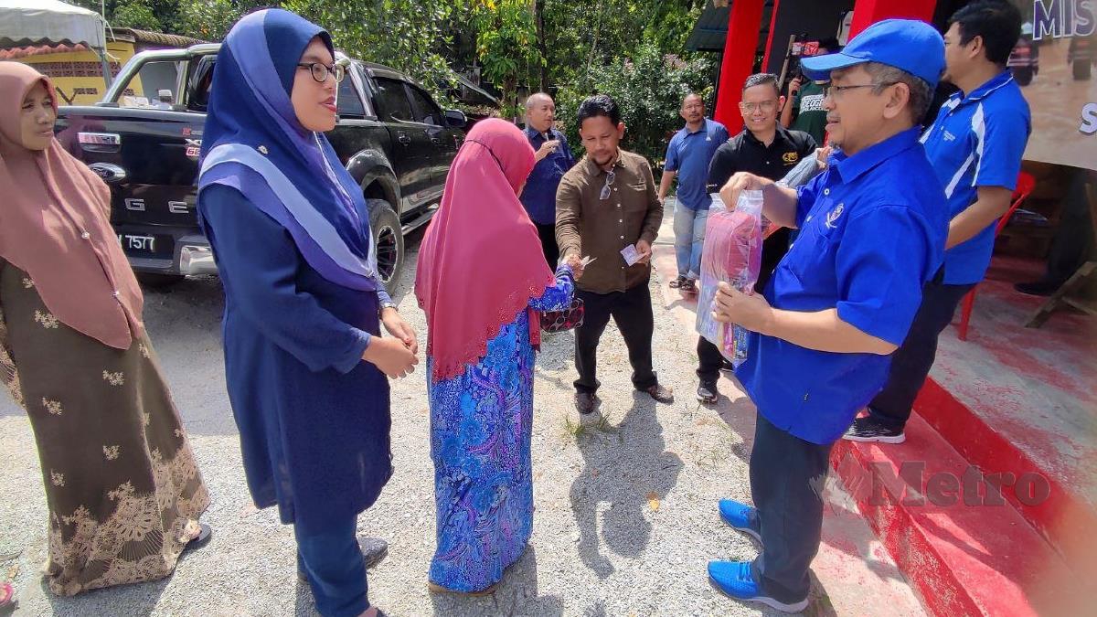 MOHD Zubir menyampaikan sumbangan kepada Siti Rozilah. FOTO Nurul Fatihah Sulaini