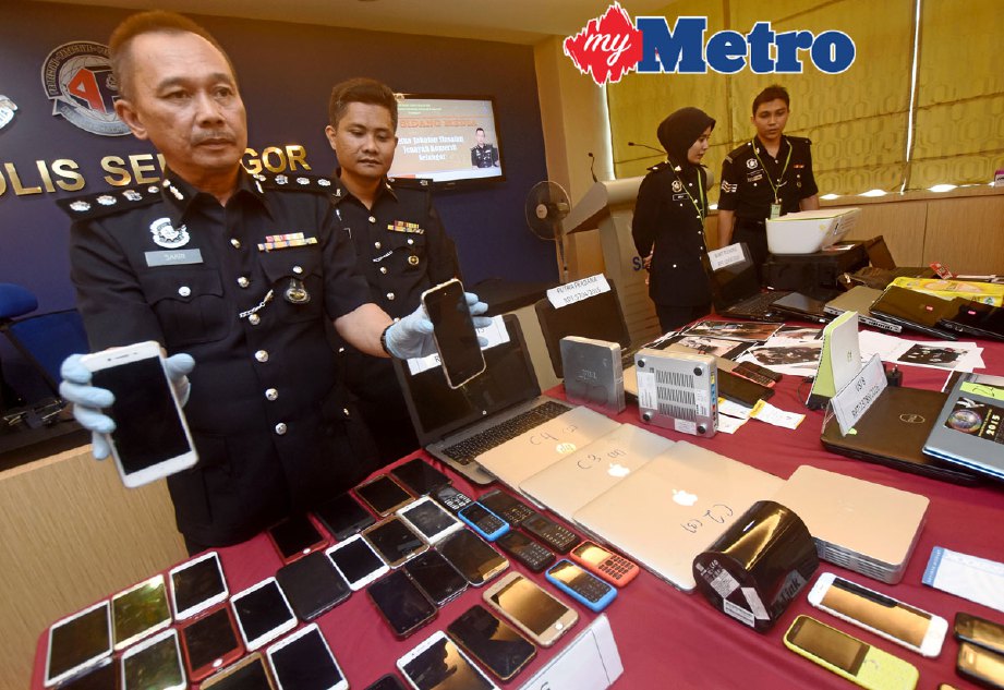 Mohd Shakri (kiri) menunjukkan barang kes yang dirampas pada sidang media berkaitan kejayaan anggota Polis menumpaskan sindiket African Scam di IPK Selangor. FOTO Mohd Asri Saifuddin Mamat