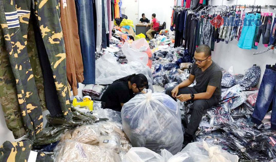 PEGAWAI KPDNKK melakukan pemeriksaan di   premis yang menjual pakaian cetak rompak diserbu di Jalan Kenanga, semalam. FOTO NSTP