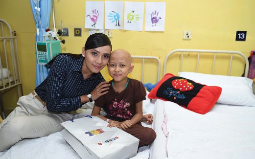 SITI Elizad bersama salah seorang  kanak-kanak pesakit kanser.
