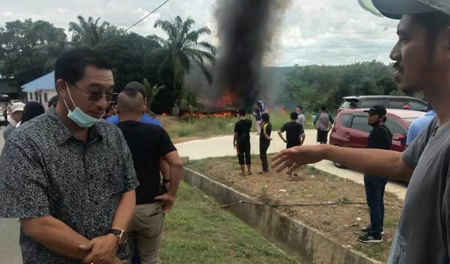 ABDUL Rahman Kongkawang (kiri) menerima berita sedih apabila rumahnya di Kampung Muanad Tiga, musnah terbakar. FOTO Ihsan pembaca