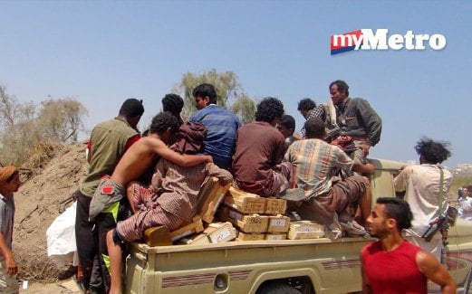 ORANG ramai duduk di atas lori selepas menjarah senjata dari depoh tentera di Aden.
