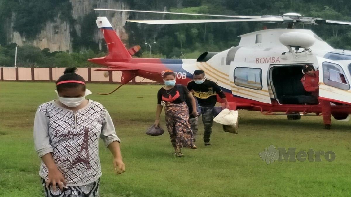 WANITA Orang Asli yang terperangkap di Pos Gob dibawa oleh helikopter Unit Udara JBPM sebelum dikejarkan ke HGM. FOTO RAMLI IBRAHIM