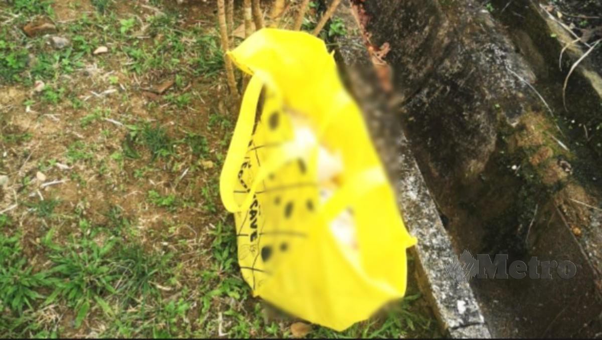 BEG kuning yang mengandungi mayat bayi perempuan ditemui di Masjid Kariah Kampung Sri Jemapoh. FOTO Ihsan polis.