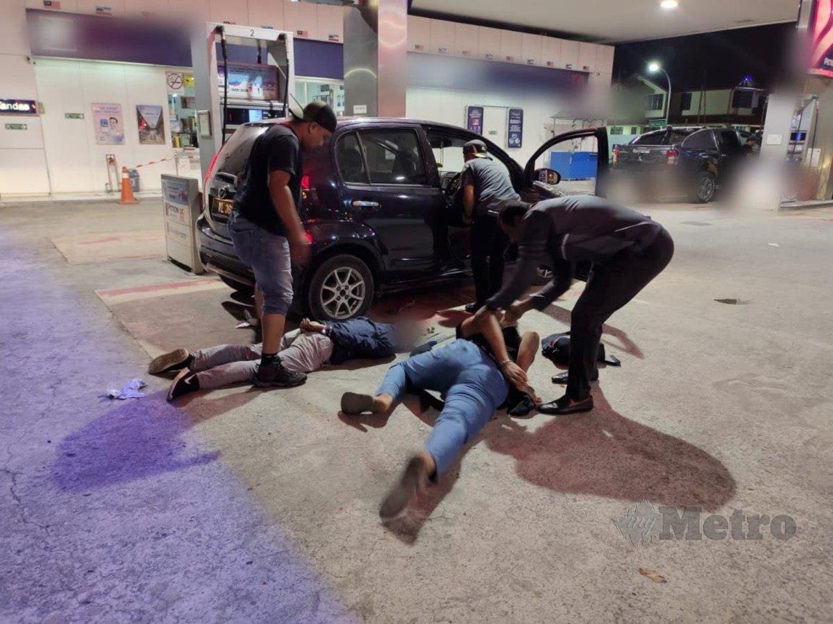 DUA bekas banduan diberkas pasukan D9 JSJ Kontinjen Sabah di sebuah stesen minyak di Jalan Lintas, Luyang. FOTO ihsan polis 