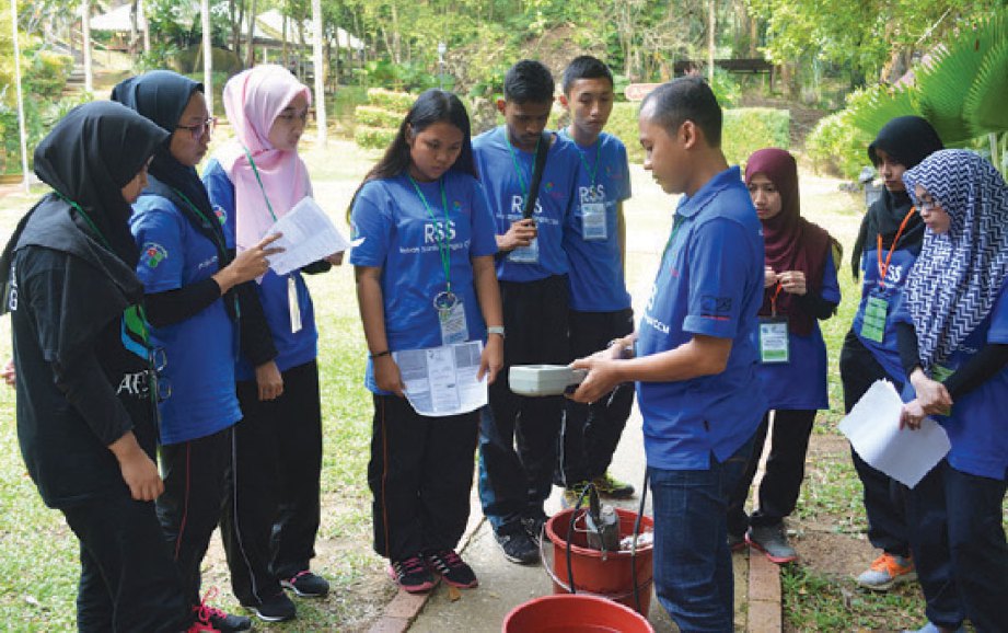SEORANG petugas CCM menunjukkan bacaan kualiti air kepada pelajar.