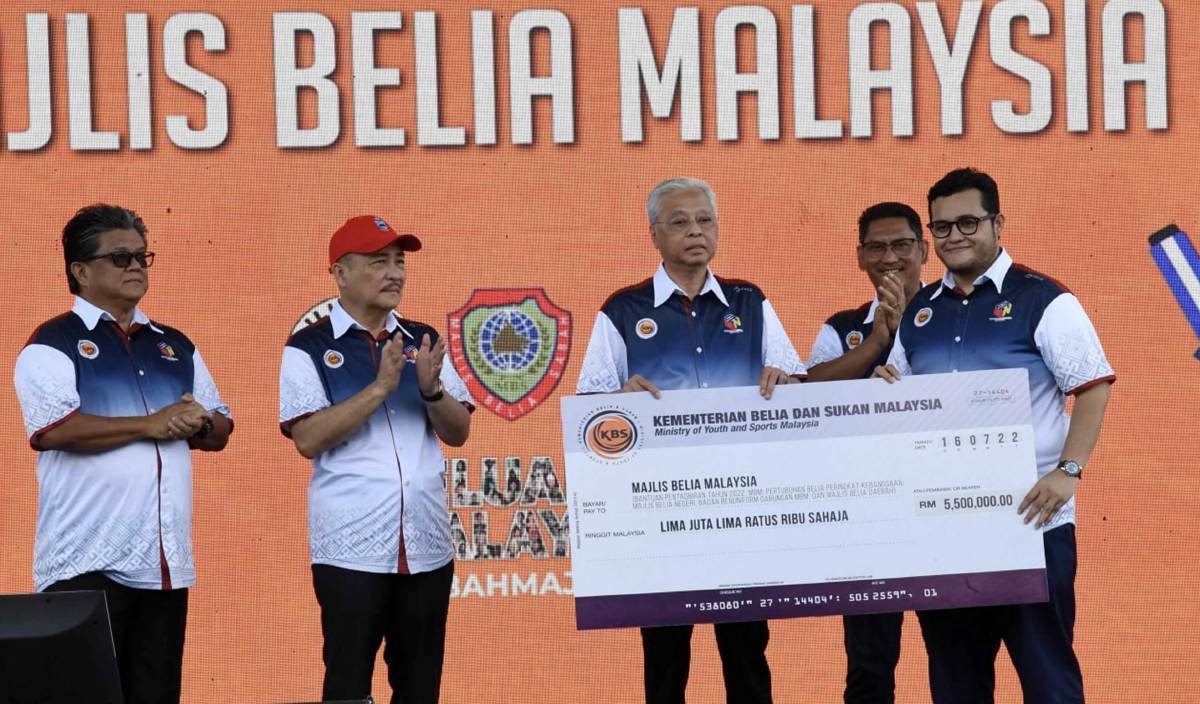 ISMAIL Sabri (tengah) menyerahkan replika cek bernilai RM 5,500,000 kepada Presiden Majlis Belia Malaysia Mohd Izzat Afifin (kanan) sebagai bantuan kepada belia sempena Sambutan Hari Belia Negara Peringkat Kebangsaan di Pekan Tuaran hari ini. FOTO BERNAMA