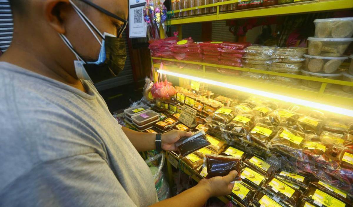 HAFIZI menyusun atur produk jualannya setelah hampir lima bulan kedai miliknya tidak beroperasi sepanjang tempoh PKP dan Pelan Pemulihan Negara Fasa 1. FOTO Syafeeq Ahmad