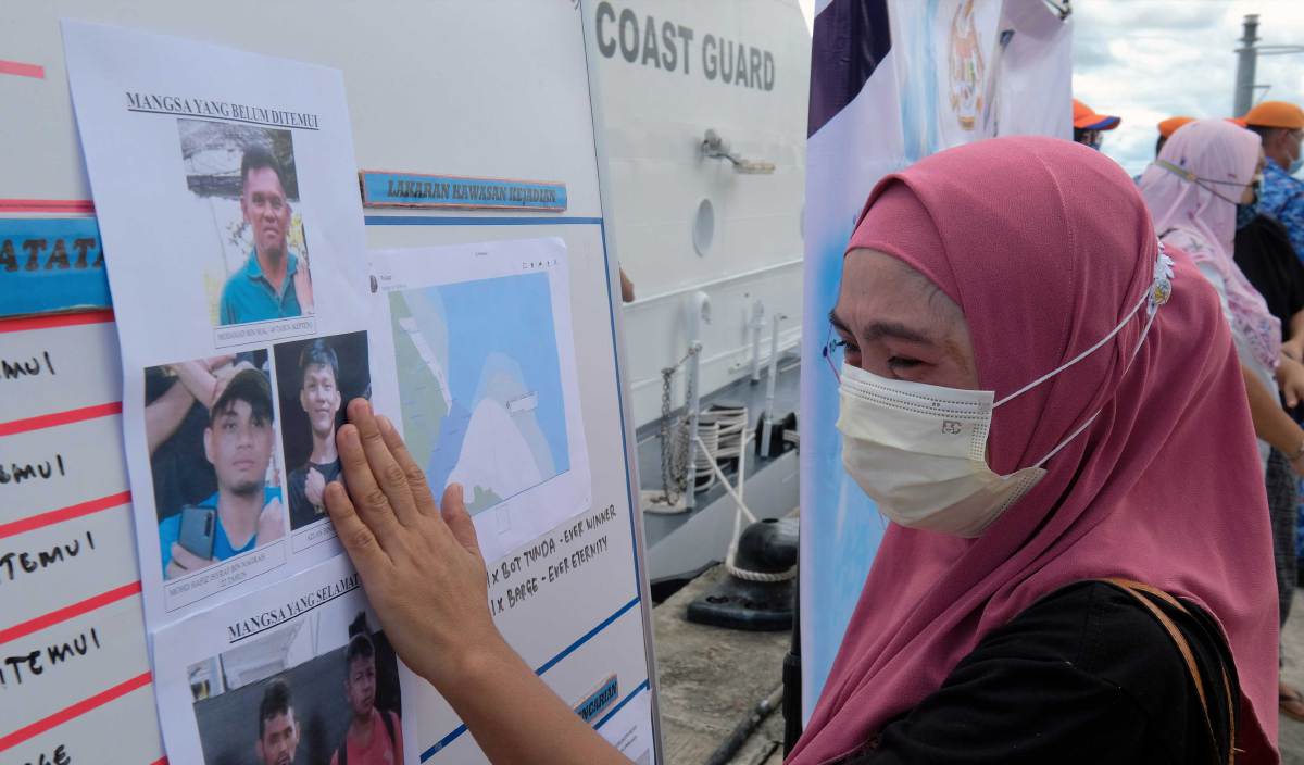 SITI Ratnah mengusap gambar adiknya Azlan Hassan, merupakan mangsa bot tunda karam yang masih belum dijumpai ketika menunggu perkhabaran operasi pencarian di jeti Agensi Penguatkuasaan Maritim Malaysia (APMM) pada 15 Januari lalu. FOTO BERNAMA