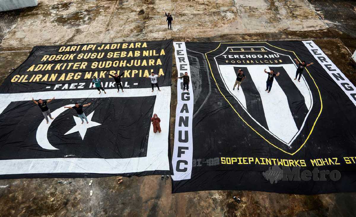 Geng 12 FC menyiapkan bendera negeri dan kain rentang bersaiz gergasi menjelang perlawanan akhir Piala Malaysia JDT. -FOTO Ghazali Kori