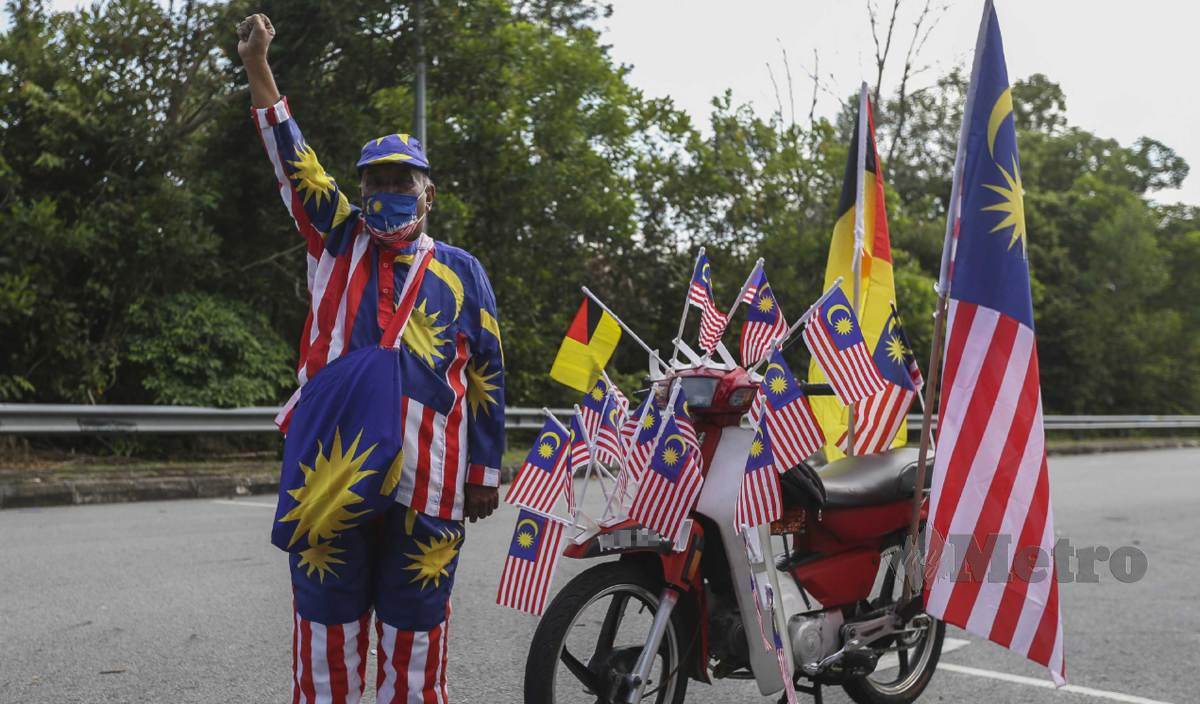 JAMALUDDIN lengkap berpakaian baju Melayu khas berkonsepkan bendera Malaysia bersama motosikal yang dihiasi Jalur Gemilang. FOTO Azrul Edham Mohd Aminuddin