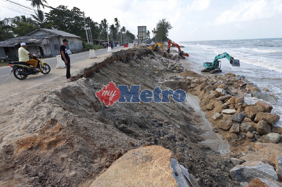 Kerja-kerja penambakan giat dijalankan akibat tanah runtuh pada tengah malam tadi di pantai Kampung Kolam, Mengabang Telipot. FOTO Ghazali Kori 
