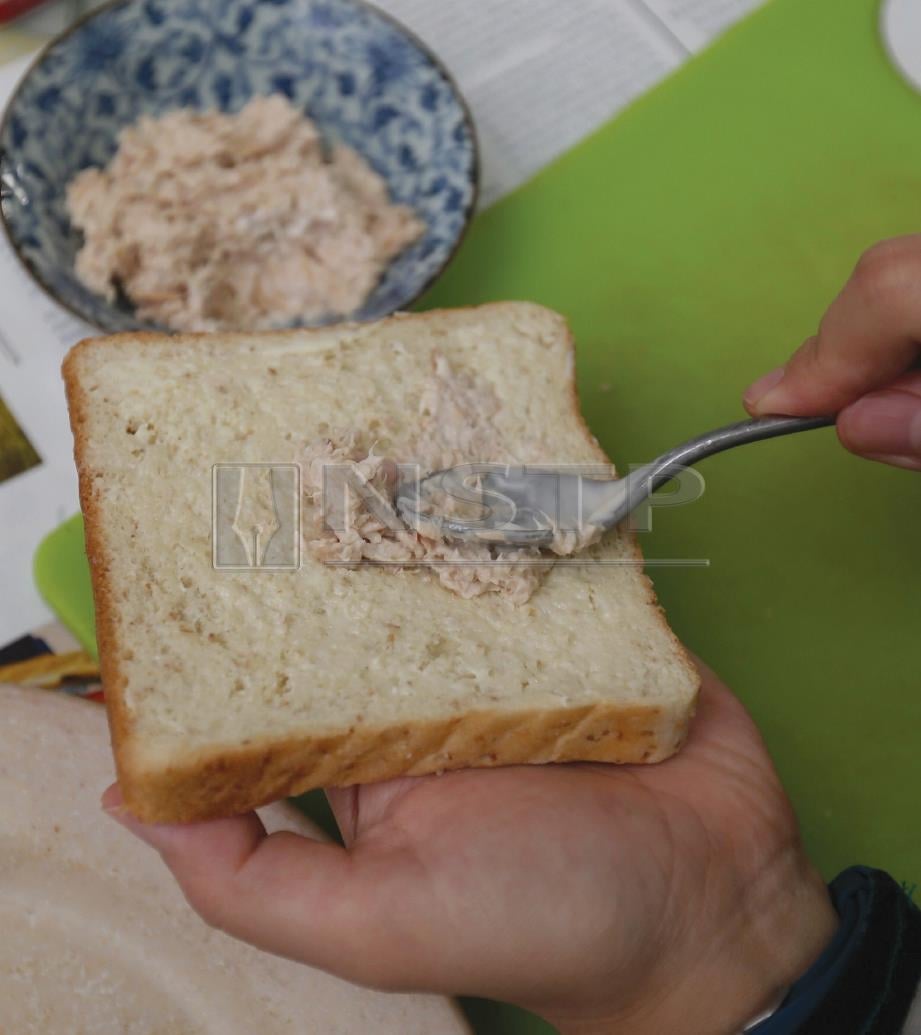 2. SAPU mentega di atas roti. Letakkan tuna yang dicampur mayonis. FOTO Zunnur Al Shafiq.