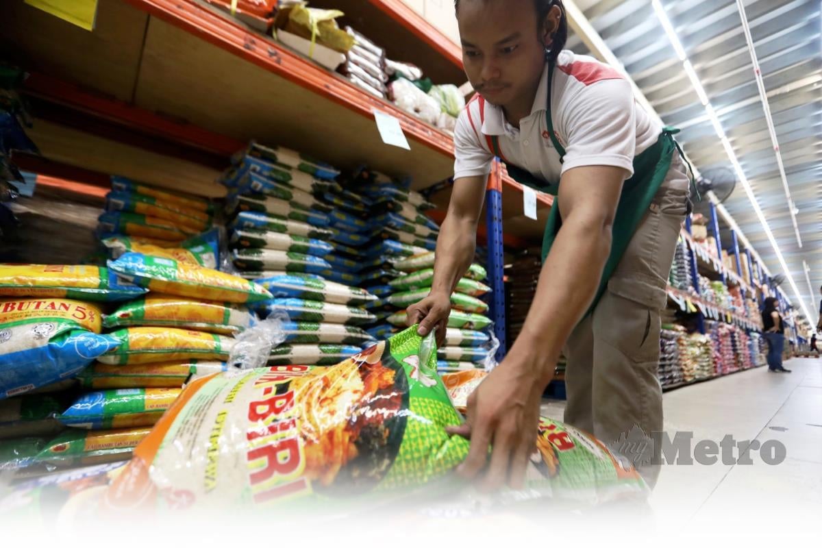PEKERJA  menyusun peket beras ketika tinjauan harga beras di pasar raya di sekitar Shah Alam. FOTO AHMAD UKASYAH