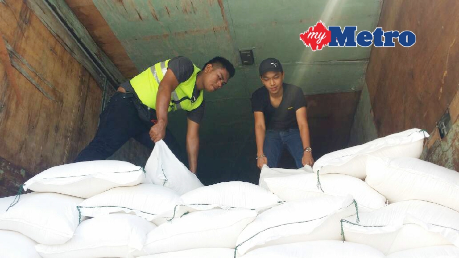 Anggota AKSEM Bukit Kayu Hitam memeriksa beras pulut yang dirampas. FOTO Zuliaty Zulkiffli 