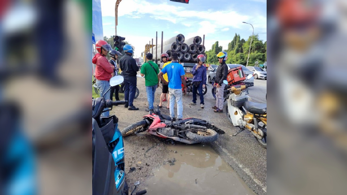 KEADAAN motosikal dinaiki seorang kerani yang terlanggar lubang sebelum terjatuh dan digilis treler. FOTO Ihsan Pembaca