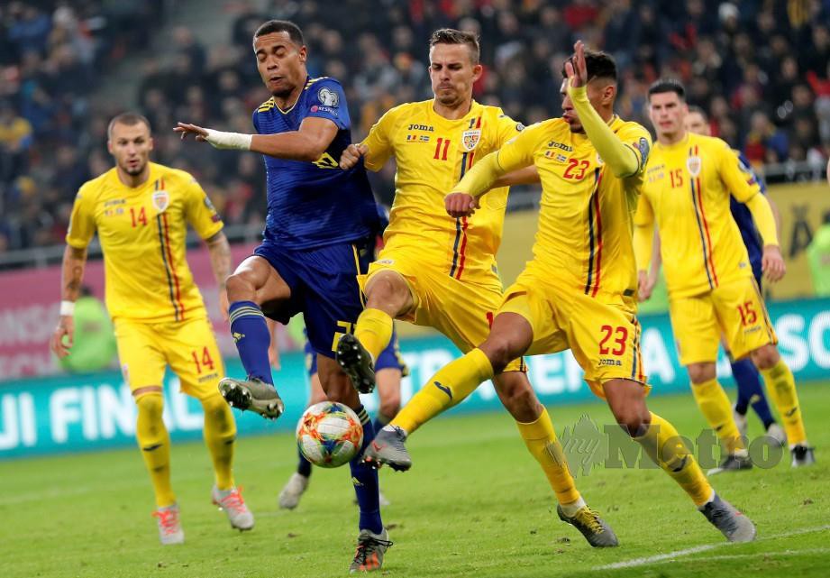 QUAISON (dua kiri) dihalang pemain Romania, Nicuso Bancu (tengah) dan Florinel Coman (dua kanan). — FOTO EPA